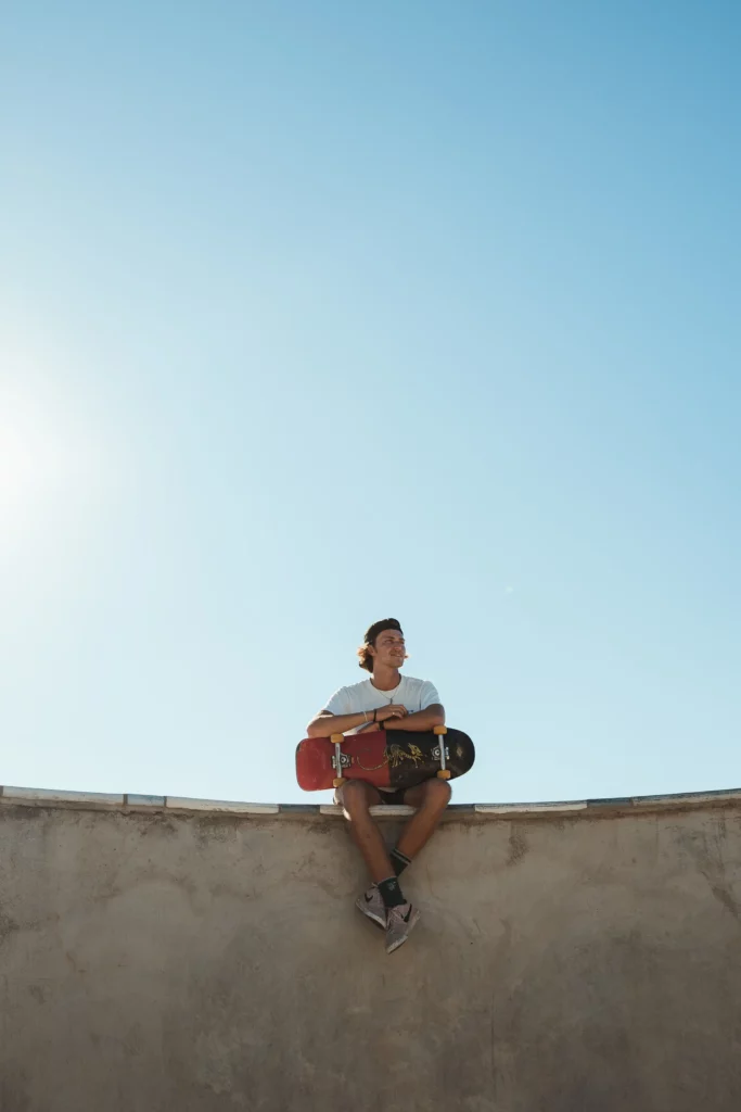 chico sentado en una rampa de skate con una tabla