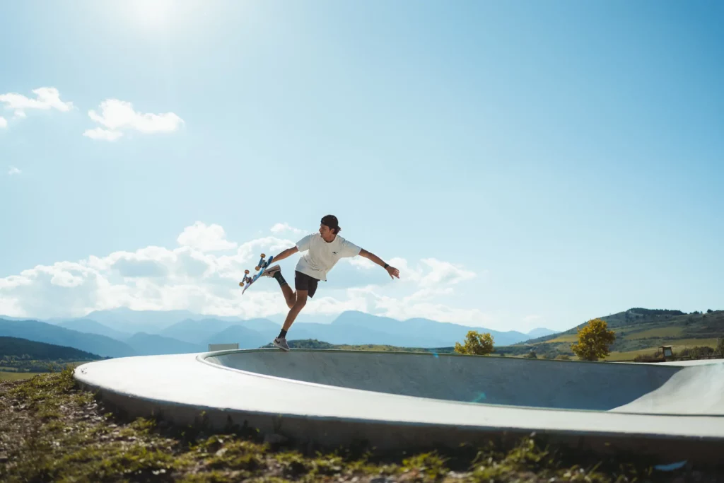 chico haciendo pirueta con un skate en lo alto de una pista